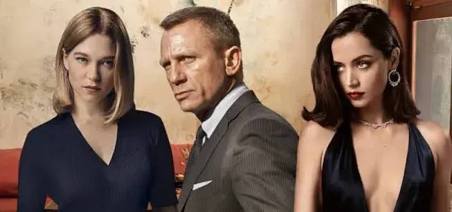 Daniel Craig en James Bond, costume gris, entouré de deux femmes brunes et blondes dans un visuel de Mourir peut attendre
